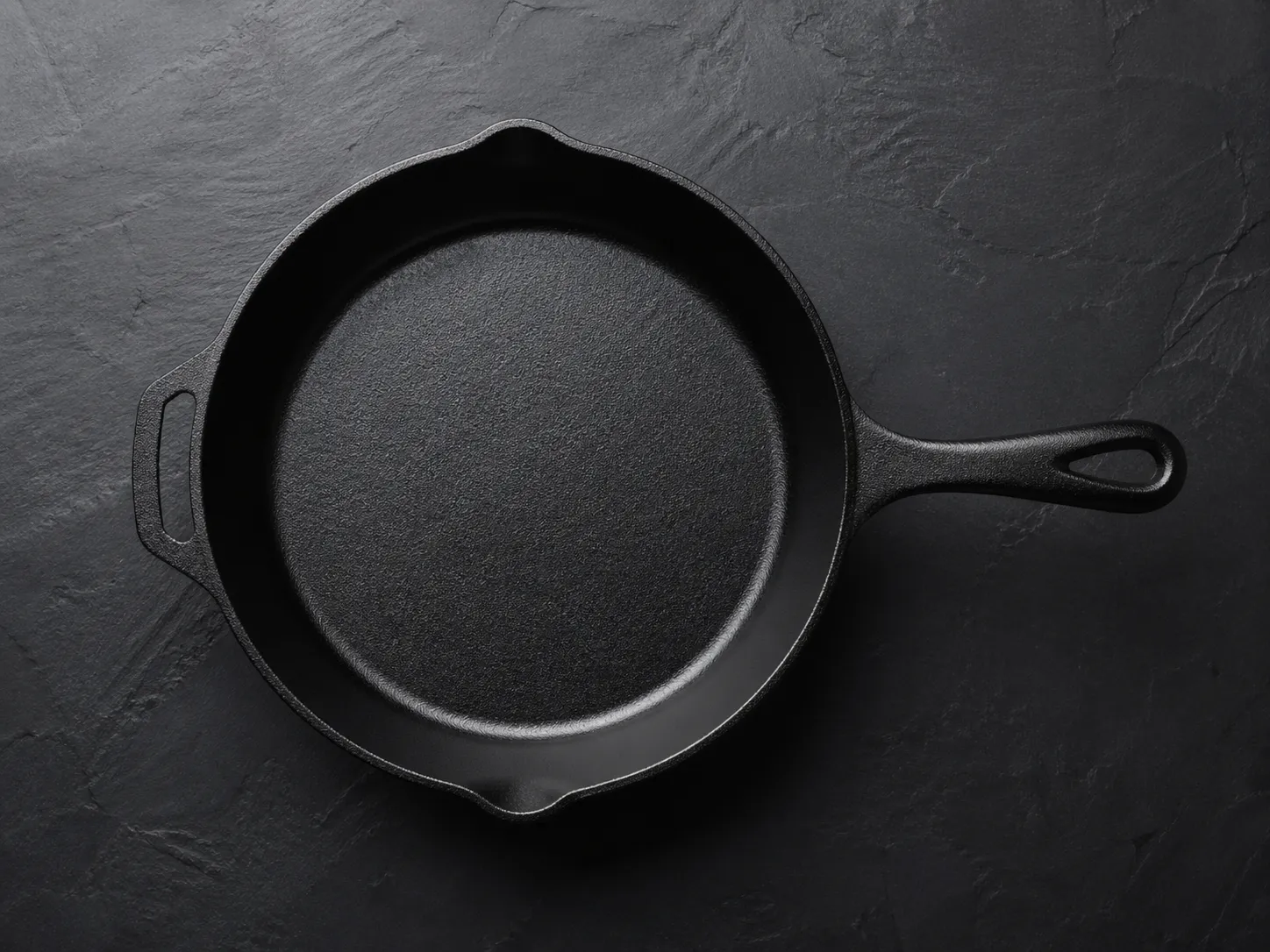 Premium black cast iron skillet on dark slate