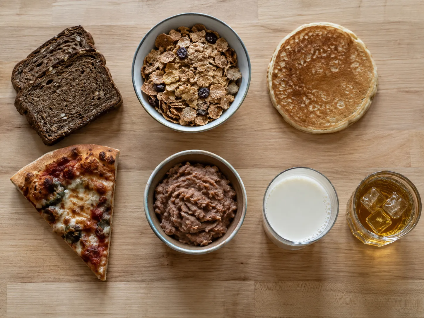 Dark bread, cereal, pancakes, pizza, refried beans, soy milk and spirits laid out together, all on the study's ultra-processed food list.